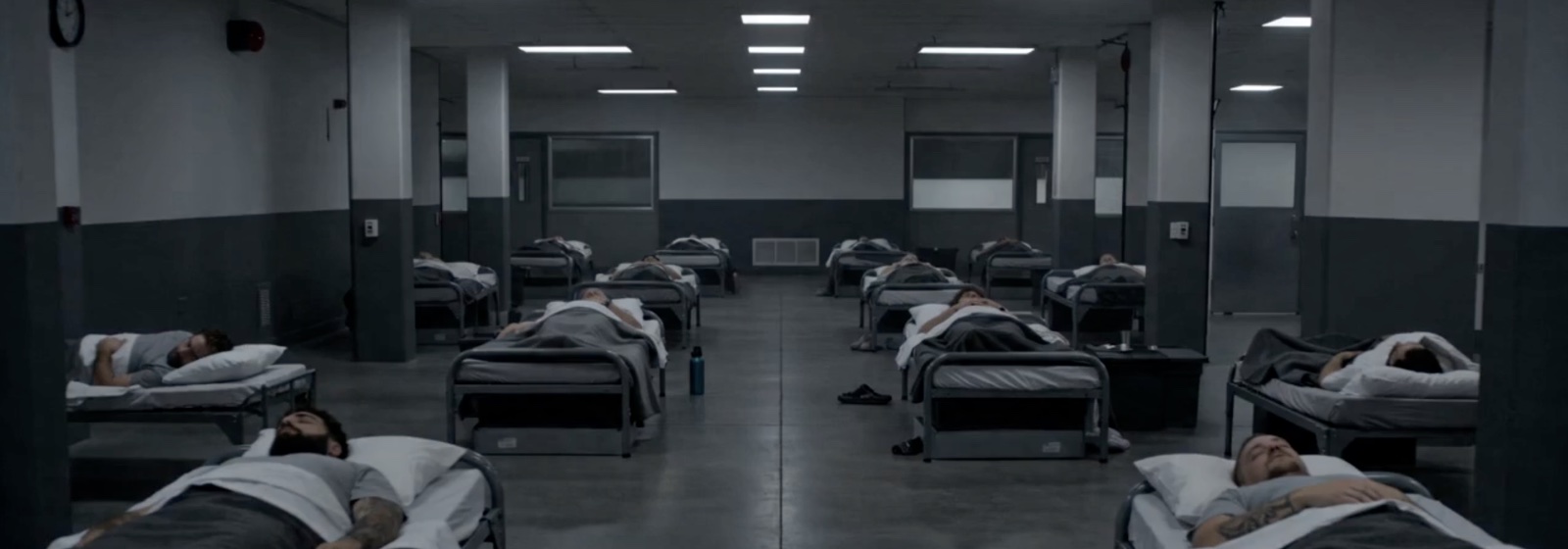 the overnight floor: rows of occupied beds under strip lighting